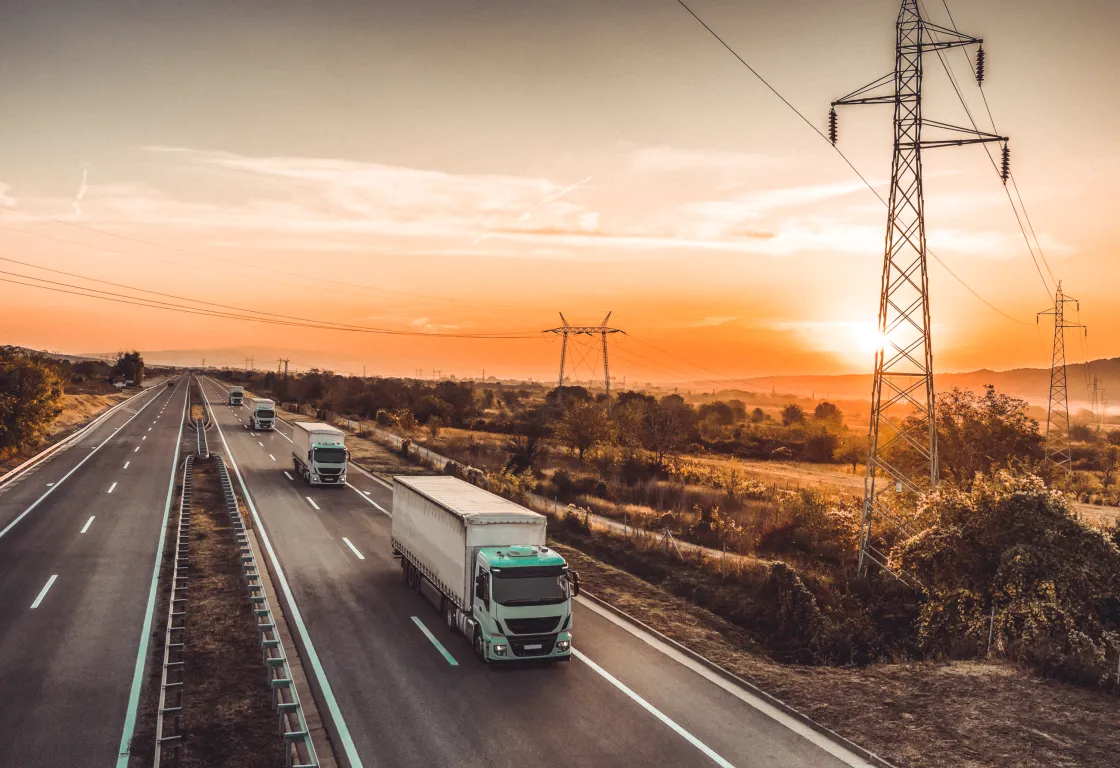 Trucks on a highway at sunset